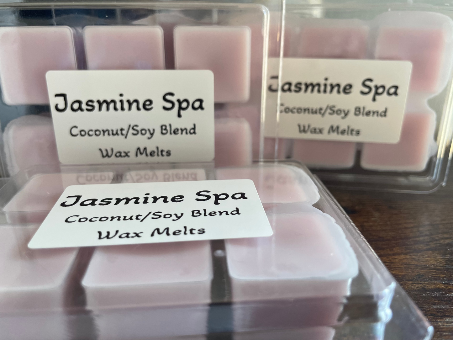 Jasmine Spa coconut/soy blend wax melts in clear packaging on a wooden surface.